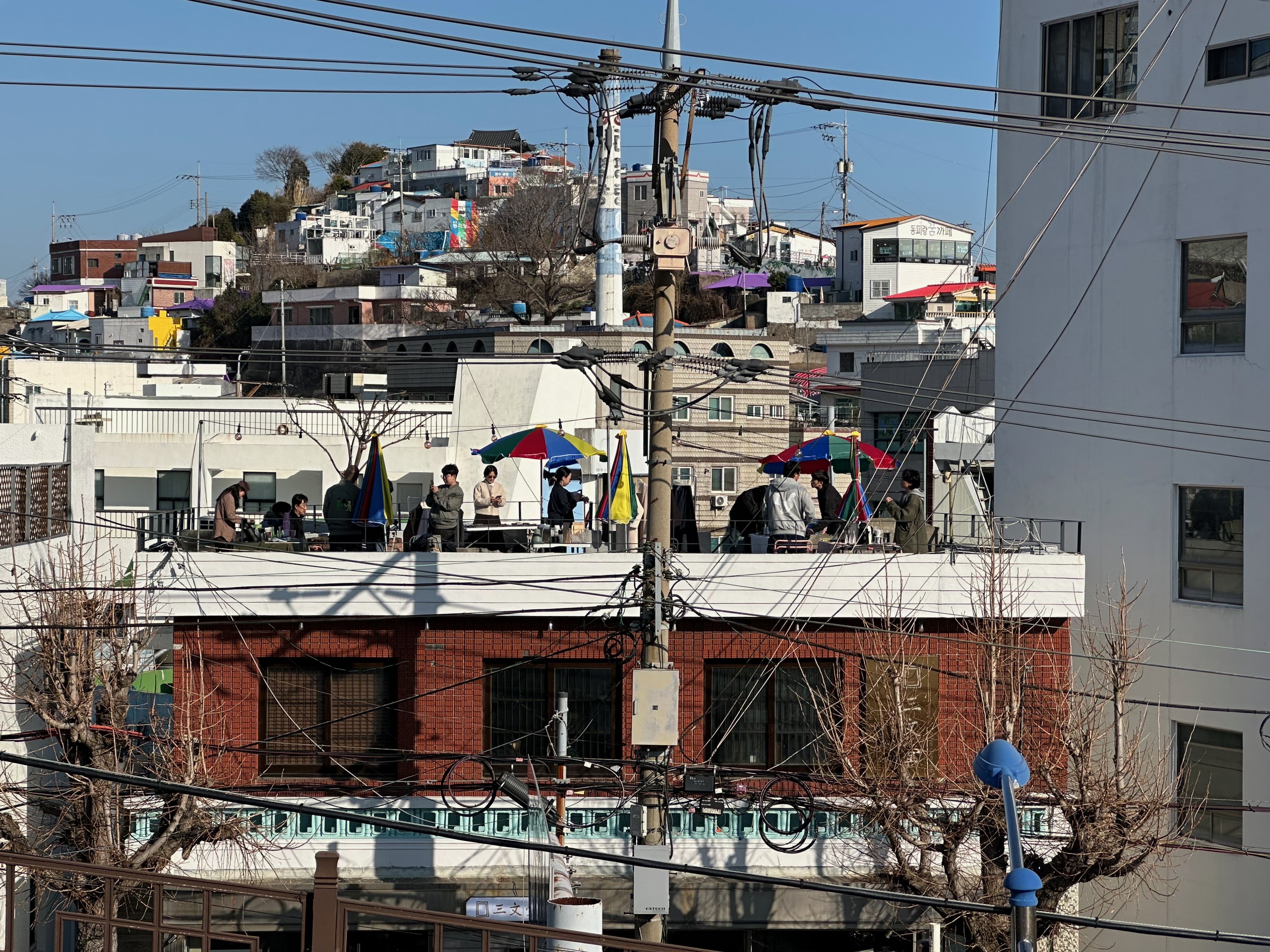 Neighborhood rooftops with people gathering together in an urban hillside setting