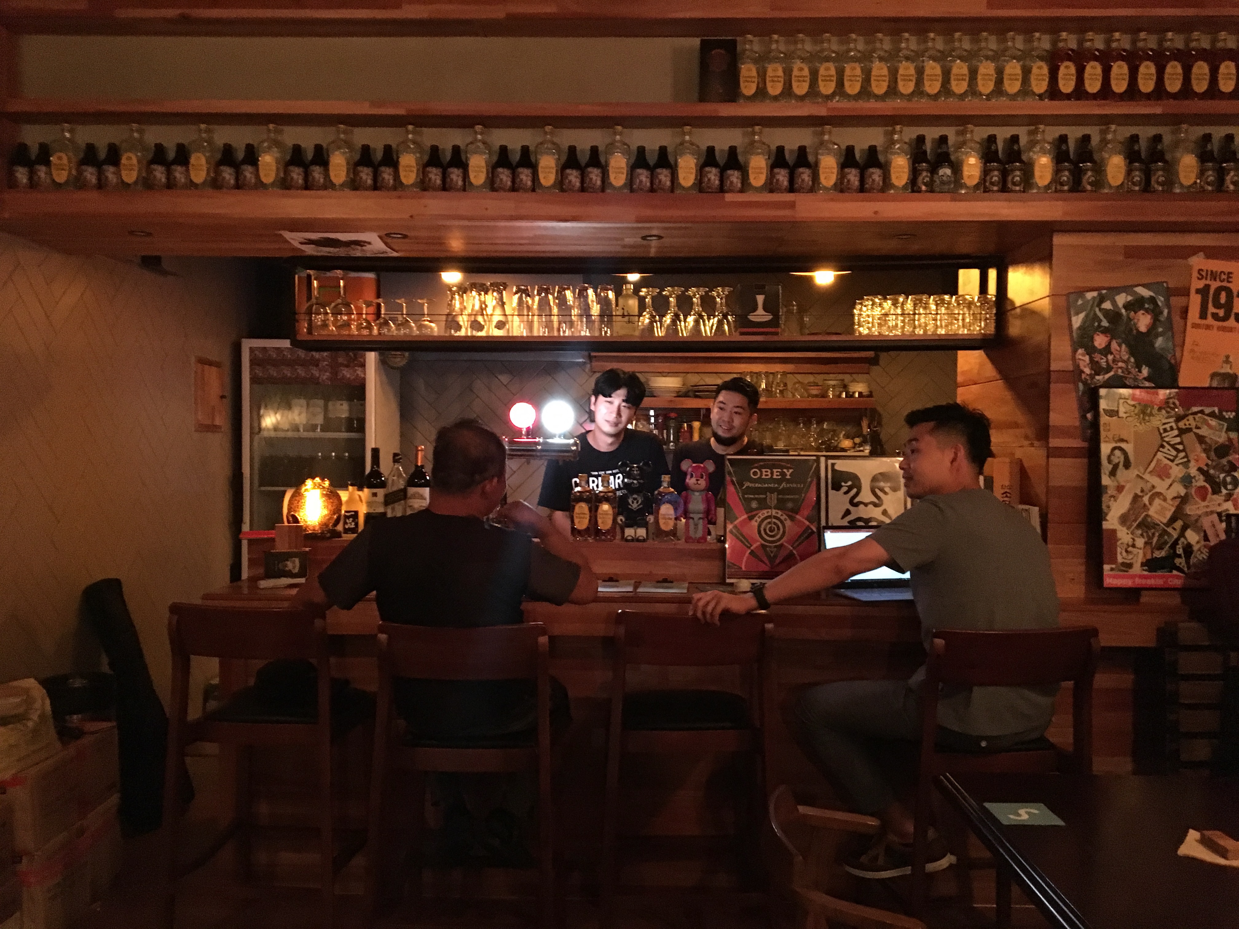 Warm bar interior with people talking across the counter