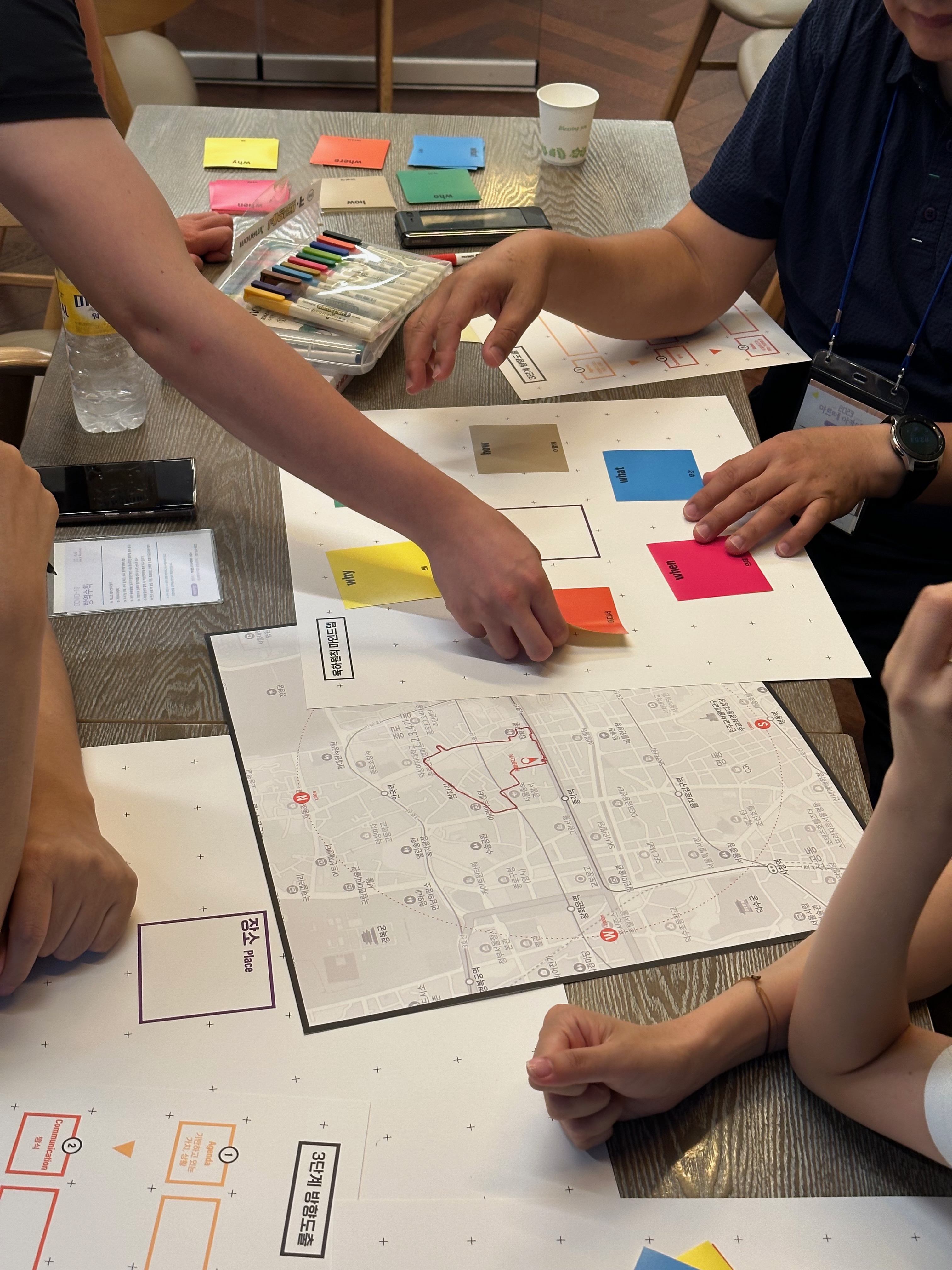 Participants using maps and colored cards during a place-based arts education workshop