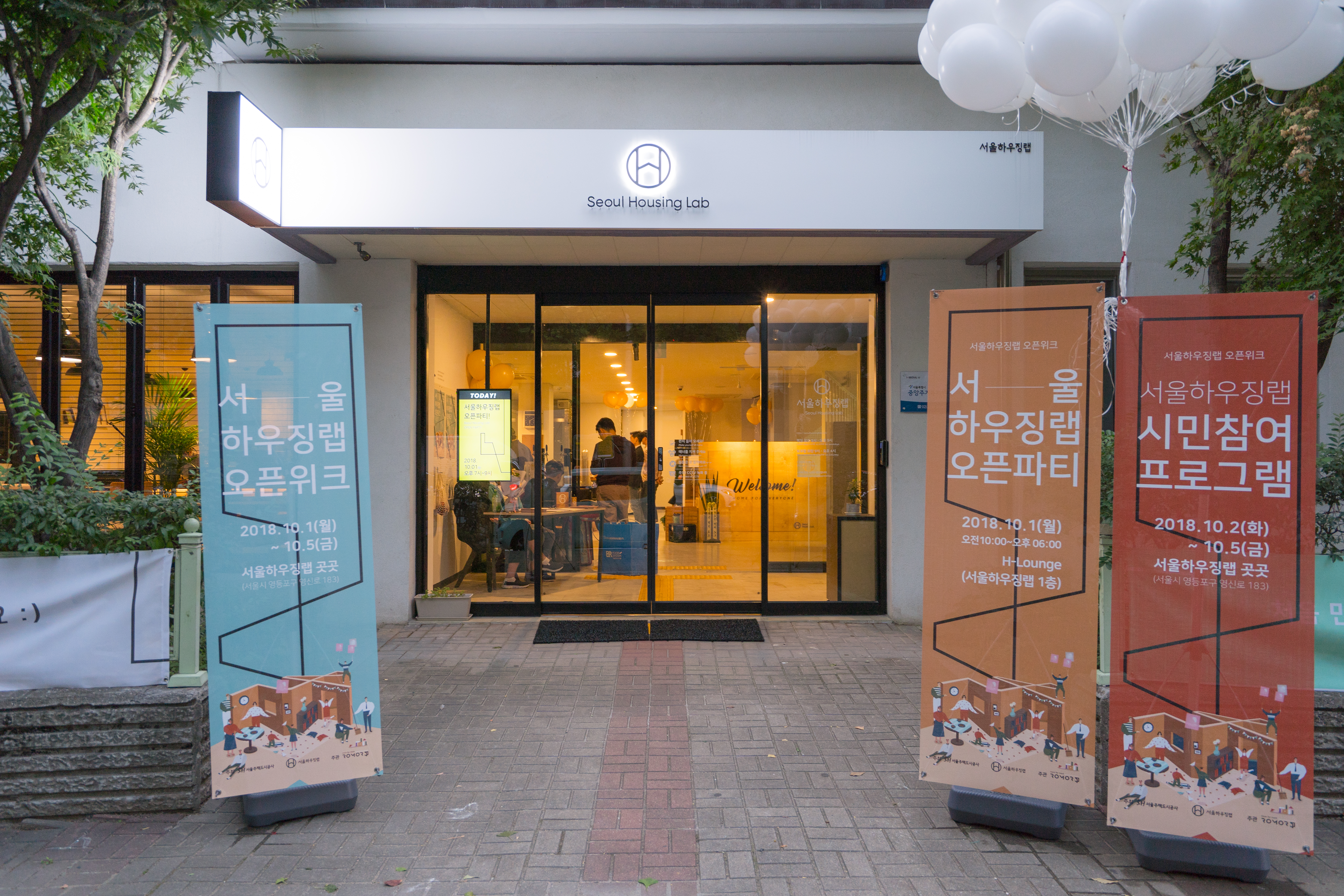 Entrance of Seoul Housing Lab during Open Week with event signboards and balloons