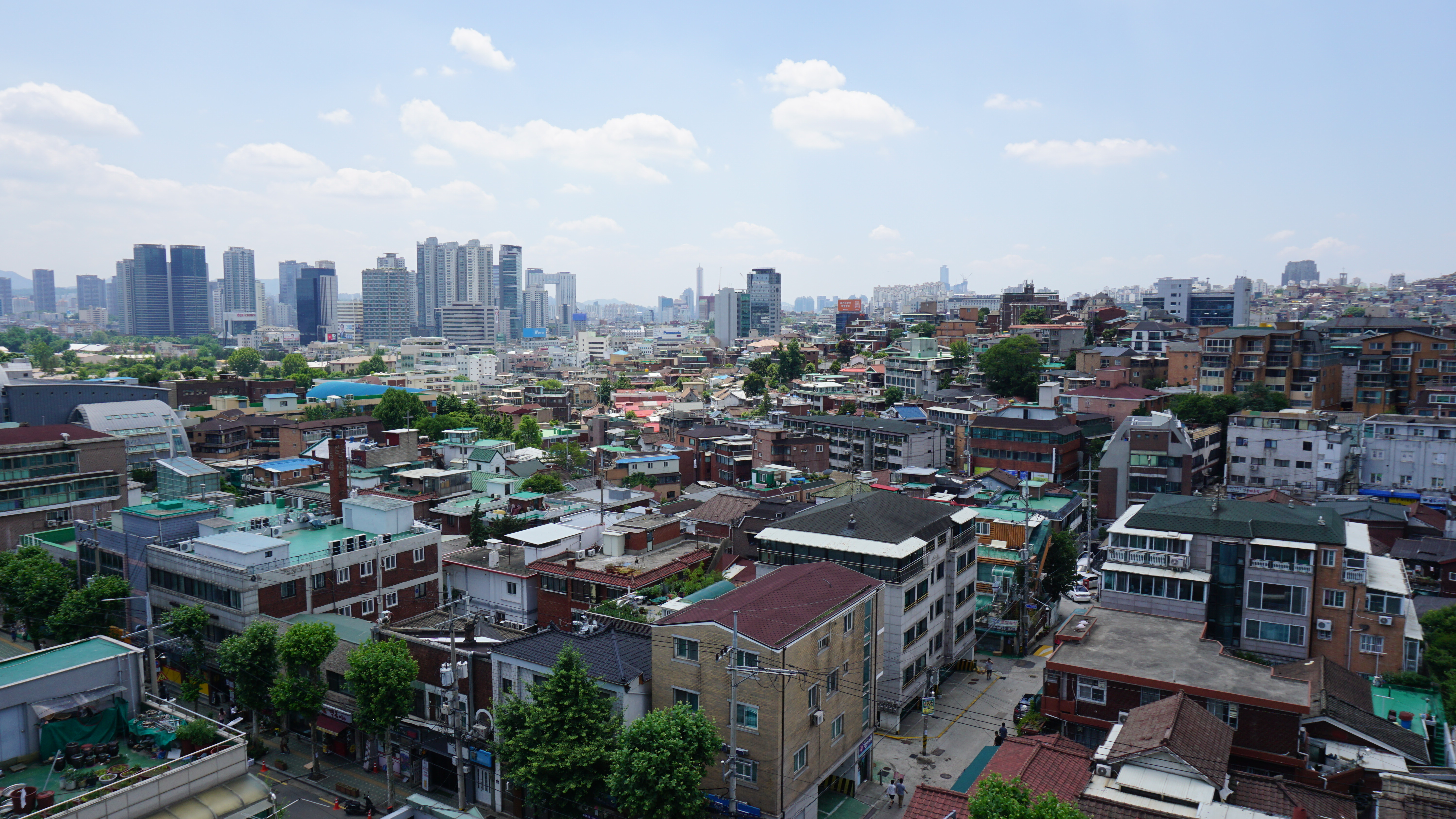 Panoramic view over Huam-dong in Seoul with dense low-rise neighborhood fabric and distant towers